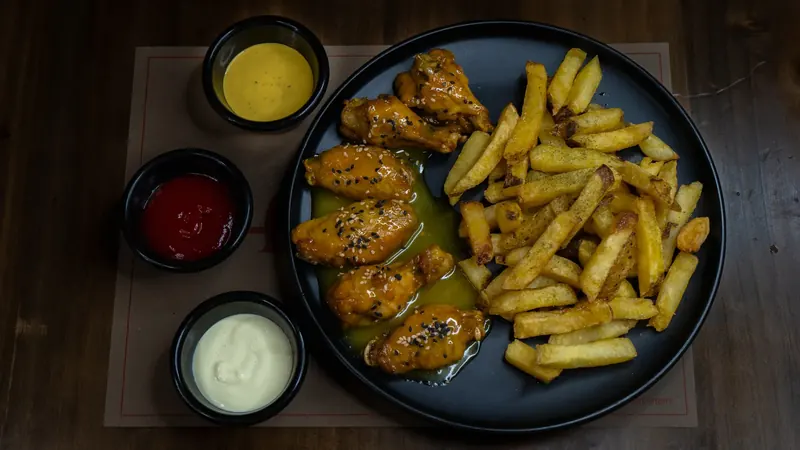 Alitas honey mustard con papas fritas